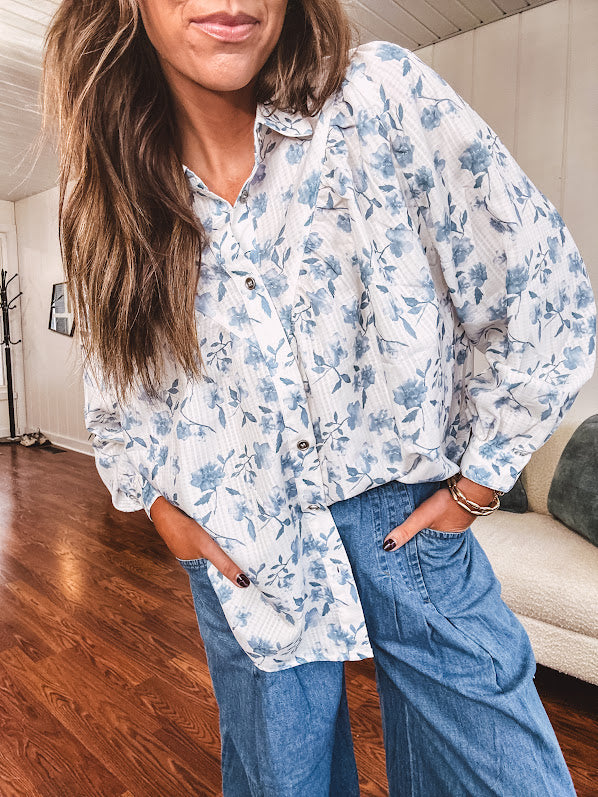 Long sleeved white button down with window pane pattern and blue watercolor florals throughout.