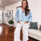 Thin, light denim flowy top with long sleeves and tie front at the neck.