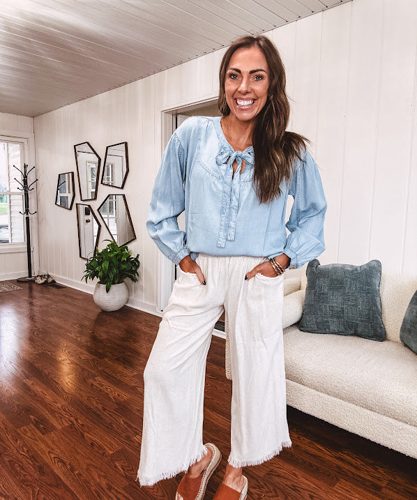 Thin, light denim flowy top with long sleeves and tie front at the neck.