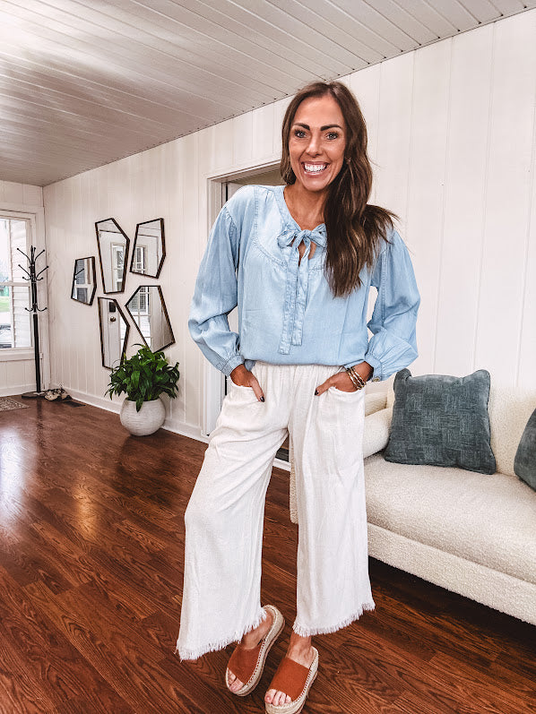 Thin, light denim flowy top with long sleeves and tie front at the neck.