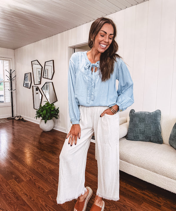 Thin, light denim flowy top with long sleeves and tie front at the neck.