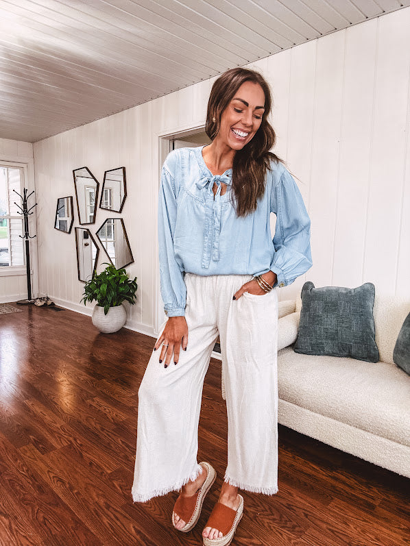 Thin, light denim flowy top with long sleeves and tie front at the neck.