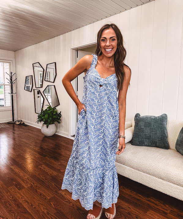 Dusty blue midi dress with white eyelet and floral embroidery throughout, gathered bust, stretchy wide straps and pockets.