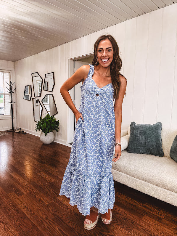 Dusty blue midi dress with white eyelet and floral embroidery throughout, gathered bust, stretchy wide straps and pockets.