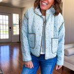 Mint green light weight quilted jacket with olive and white mini florals throughout and olive trim with snap button front and pockets.