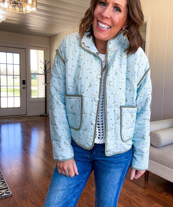 Mint green light weight quilted jacket with olive and white mini florals throughout and olive trim with snap button front and pockets.