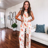 Fitted cream snap front vest with bright coral florals and blue accents with pockets.