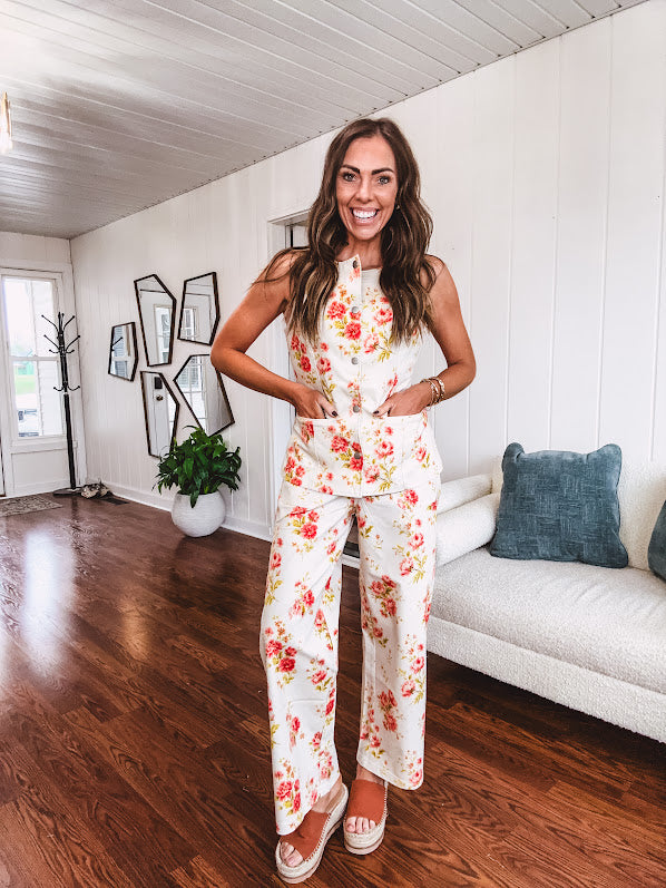 Cream wide leg pants with elastic back and button zipper front with bold coral and green florals throughout with blue accents, front and back pockets.