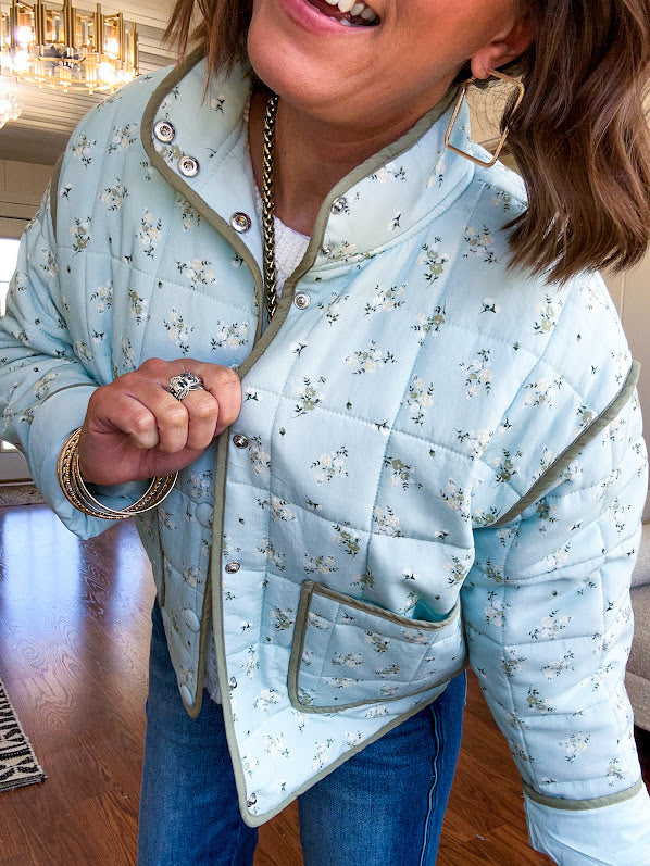 Mint green light weight quilted jacket with olive and white mini florals throughout and olive trim with snap button front and pockets.