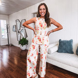 Cream wide leg pants with elastic back and button zipper front with bold coral and green florals throughout with blue accents, front and back pockets.