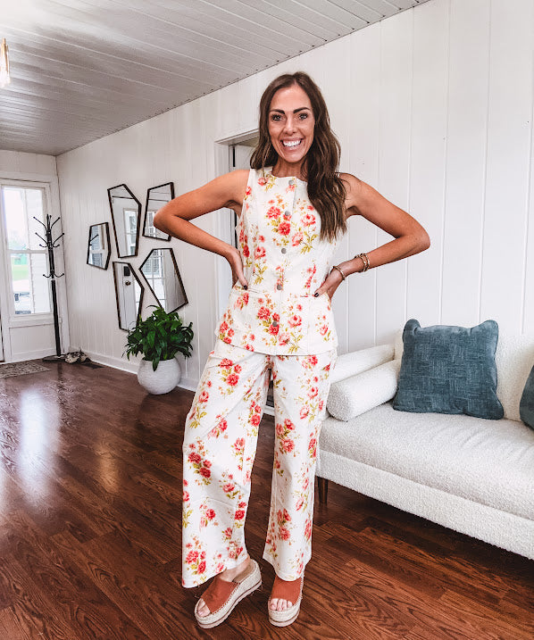 Cream wide leg pants with elastic back and button zipper front with bold coral and green florals throughout with blue accents, front and back pockets.