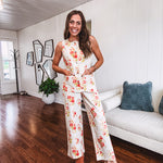 Cream wide leg pants with elastic back and button zipper front with bold coral and green florals throughout with blue accents, front and back pockets.