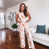 Cream wide leg pants with elastic back and button zipper front with bold coral and green florals throughout with blue accents, front and back pockets.