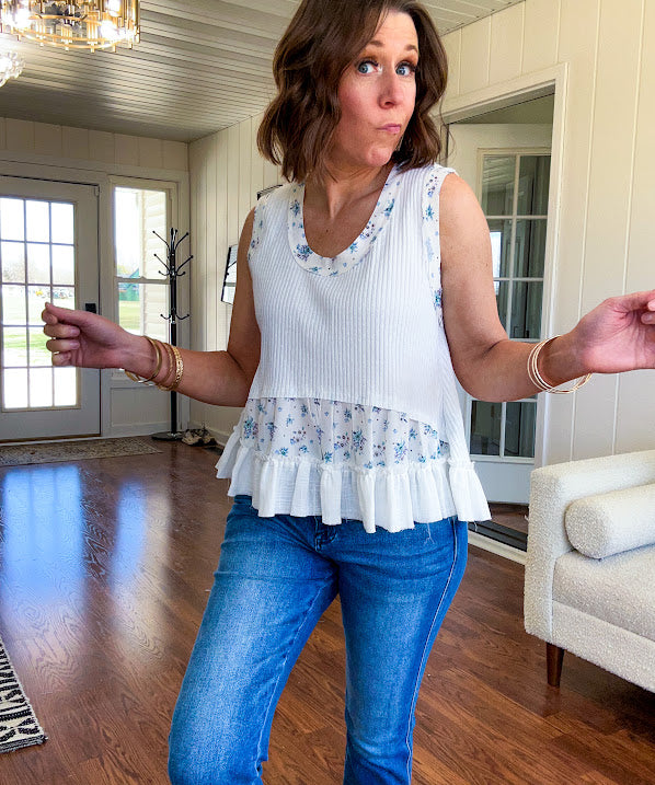 Lightweight ribbed textured white tank with blue floral trim and ruffled hem.