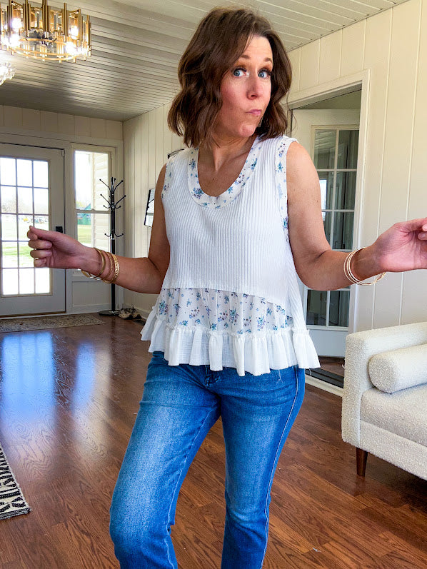 Lightweight ribbed textured white tank with blue floral trim and ruffled hem.