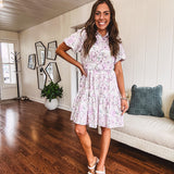 Fully lined , short lavender multi floral shirt dress with elastic waist, matching fabric belt, puff sleeves and tiered skirt.