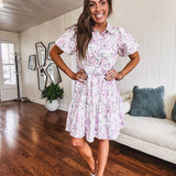 Fully lined , short lavender multi floral shirt dress with elastic waist, matching fabric belt, puff sleeves and tiered skirt.