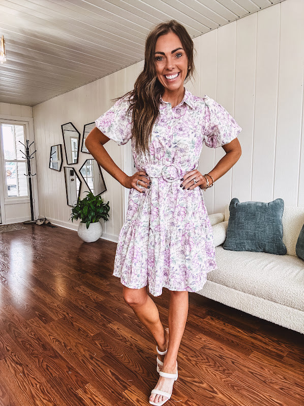 Fully lined , short lavender multi floral shirt dress with elastic waist, matching fabric belt, puff sleeves and tiered skirt.