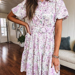Fully lined , short lavender multi floral shirt dress with elastic waist, matching fabric belt, puff sleeves and tiered skirt.