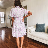 Fully lined , short lavender multi floral shirt dress with elastic waist, matching fabric belt, puff sleeves and tiered skirt.