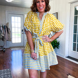 Fully lined short sleeved short dress with mustard polka dots trimmed in dusty blue, mustard and cream stripes at the mock neck and placket, ruffled cuffs, belt and hem.