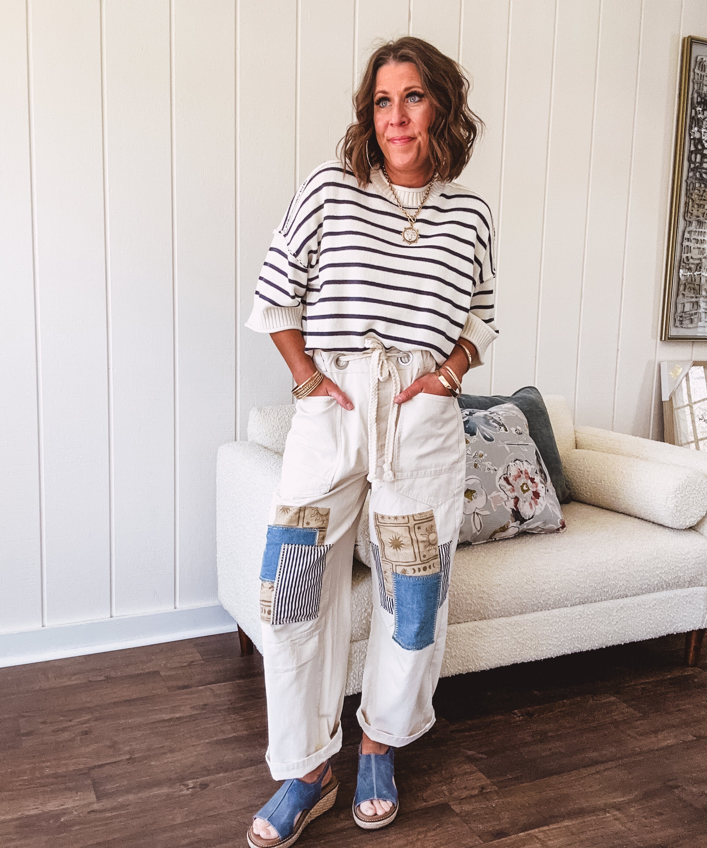 Creamy wide-leg pants, denim-like cotton material with silver grommet belt loops and a coordinating rope belt, button fly and oversized pockets, and striped patchwork in sand, denim, navy, and white creates visual interest down the legs.