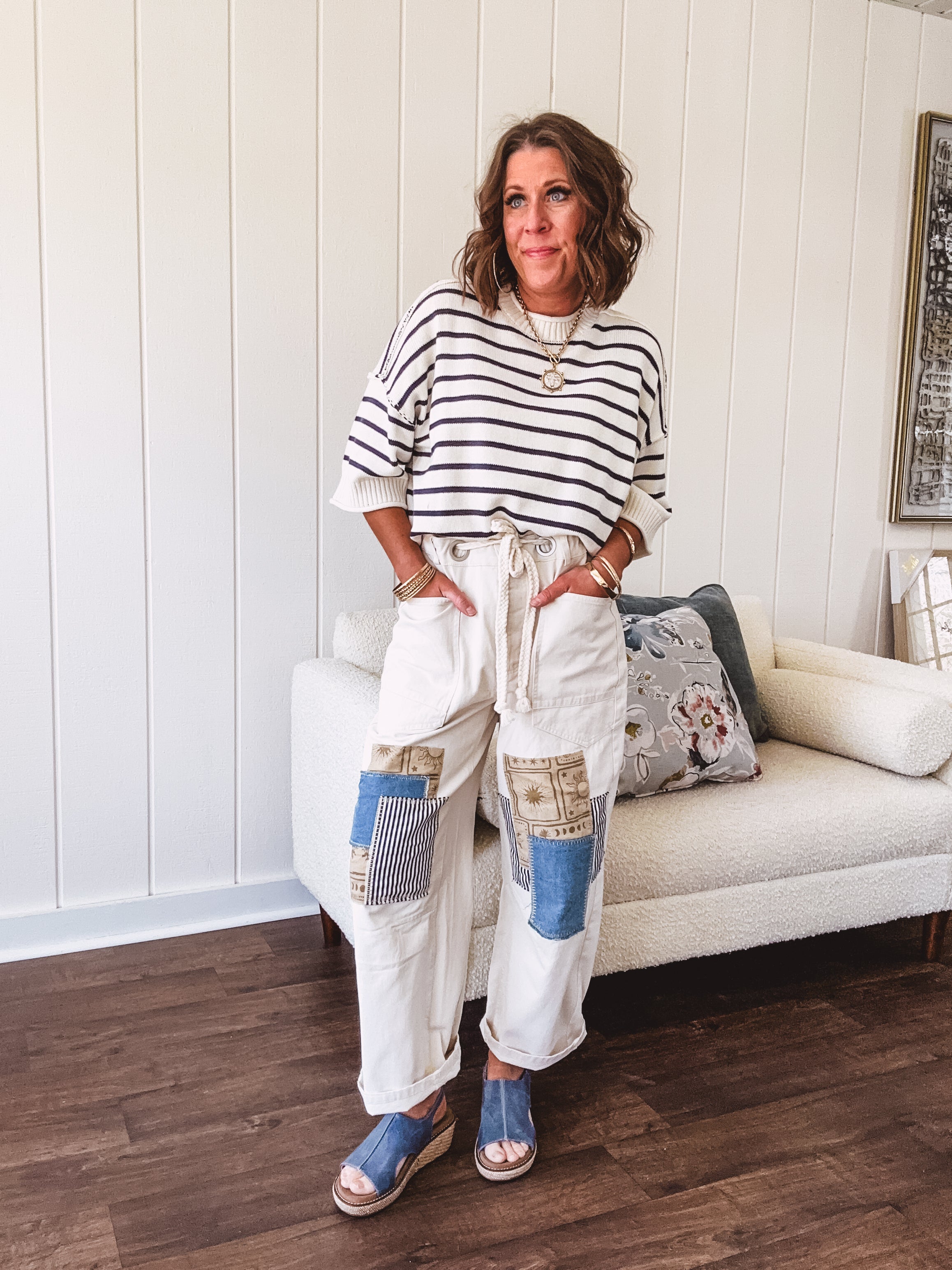 Creamy wide-leg pants, denim-like cotton material with silver grommet belt loops and a coordinating rope belt, button fly and oversized pockets, and striped patchwork in sand, denim, navy, and white creates visual interest down the legs.