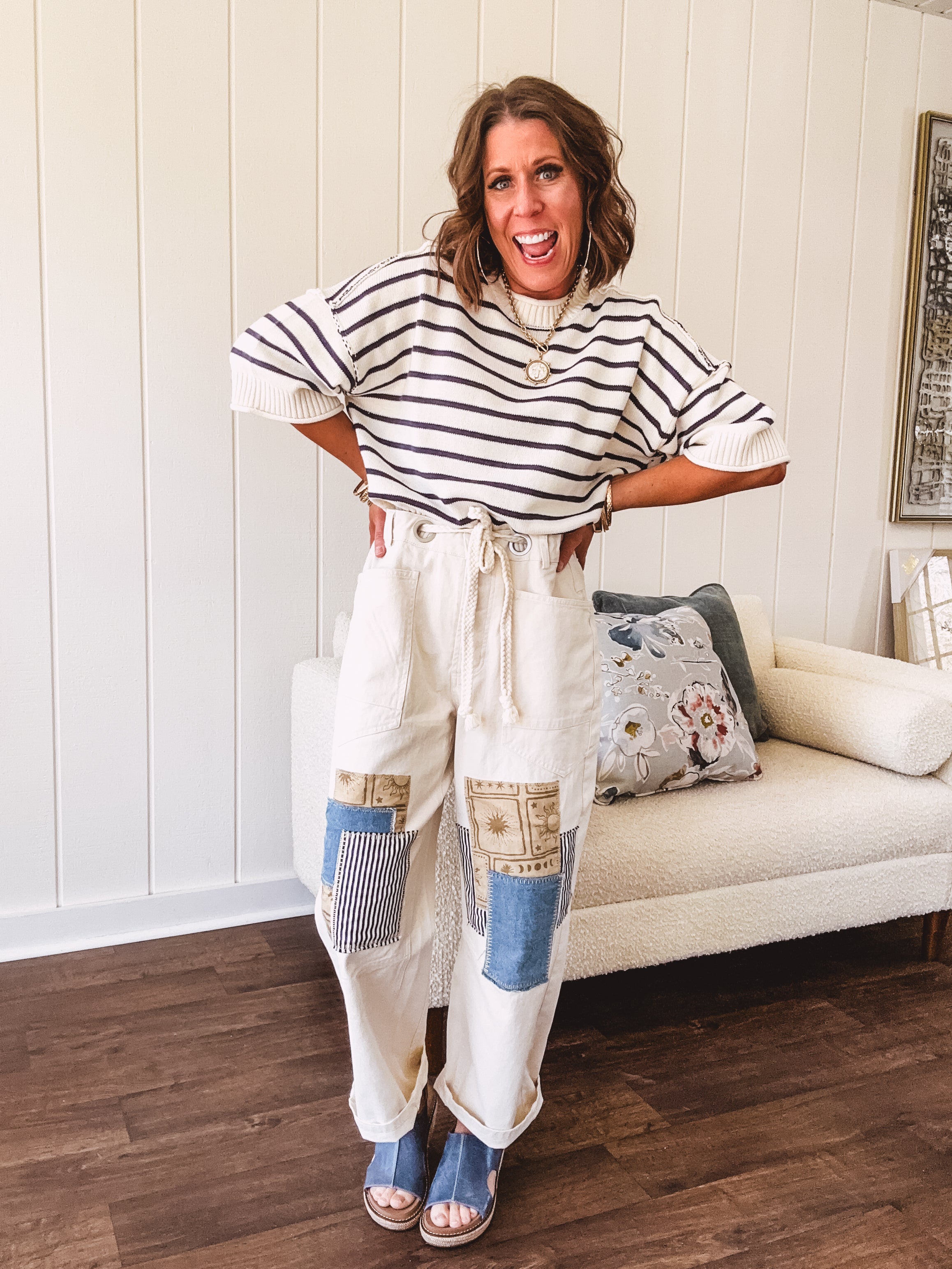 Creamy wide-leg pants, denim-like cotton material with silver grommet belt loops and a coordinating rope belt, button fly and oversized pockets, and striped patchwork in sand, denim, navy, and white creates visual interest down the legs.