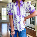 Fully lined lavender and cream blouse with lavender trim at the mock collar and V neck and cuffs, short puffed sleeves and lavender and cream embroidery throughout in an abstract pattern.