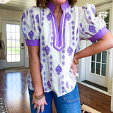 Fully lined lavender and cream blouse with lavender trim at the mock collar and V neck and cuffs, short puffed sleeves and lavender and cream embroidery throughout in an abstract pattern.