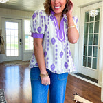 Fully lined lavender and cream blouse with lavender trim at the mock collar and V neck and cuffs, short puffed sleeves and lavender and cream embroidery throughout in an abstract pattern.
