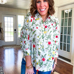 Cream 3/4 sleeve button down top with collar and pleating at the yoke with red, yellow and green florals throughout.