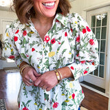 Cream 3/4 sleeve button down top with collar and pleating at the yoke with red, yellow and green florals throughout.