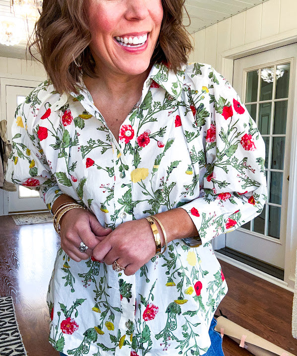 Cream 3/4 sleeve button down top with collar and pleating at the yoke with red, yellow and green florals throughout.