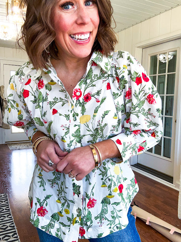 Cream 3/4 sleeve button down top with collar and pleating at the yoke with red, yellow and green florals throughout.