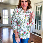 Cream 3/4 sleeve button down top with collar and pleating at the yoke with red, yellow and green florals throughout.