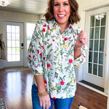 Cream 3/4 sleeve button down top with collar and pleating at the yoke with red, yellow and green florals throughout.
