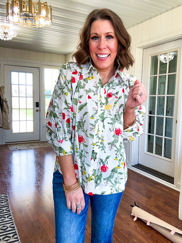 Cream 3/4 sleeve button down top with collar and pleating at the yoke with red, yellow and green florals throughout.