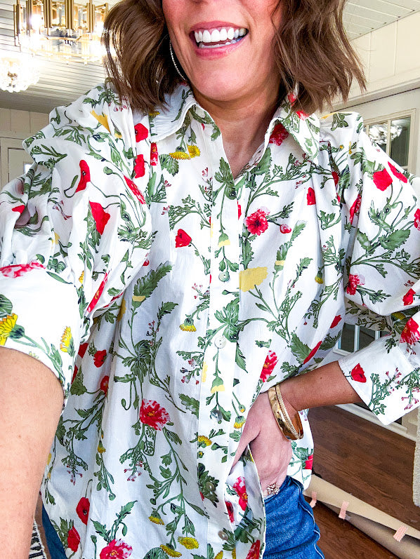 Cream 3/4 sleeve button down top with collar and pleating at the yoke with red, yellow and green florals throughout.