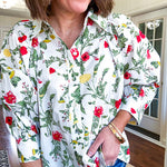 Cream 3/4 sleeve button down top with collar and pleating at the yoke with red, yellow and green florals throughout.