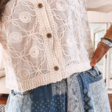 Short sheer beige button down long sleeved top with whimsical embroidery throughout and elastic cuffs.
