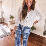 Short sheer beige button down long sleeved top with whimsical embroidery throughout and elastic cuffs.