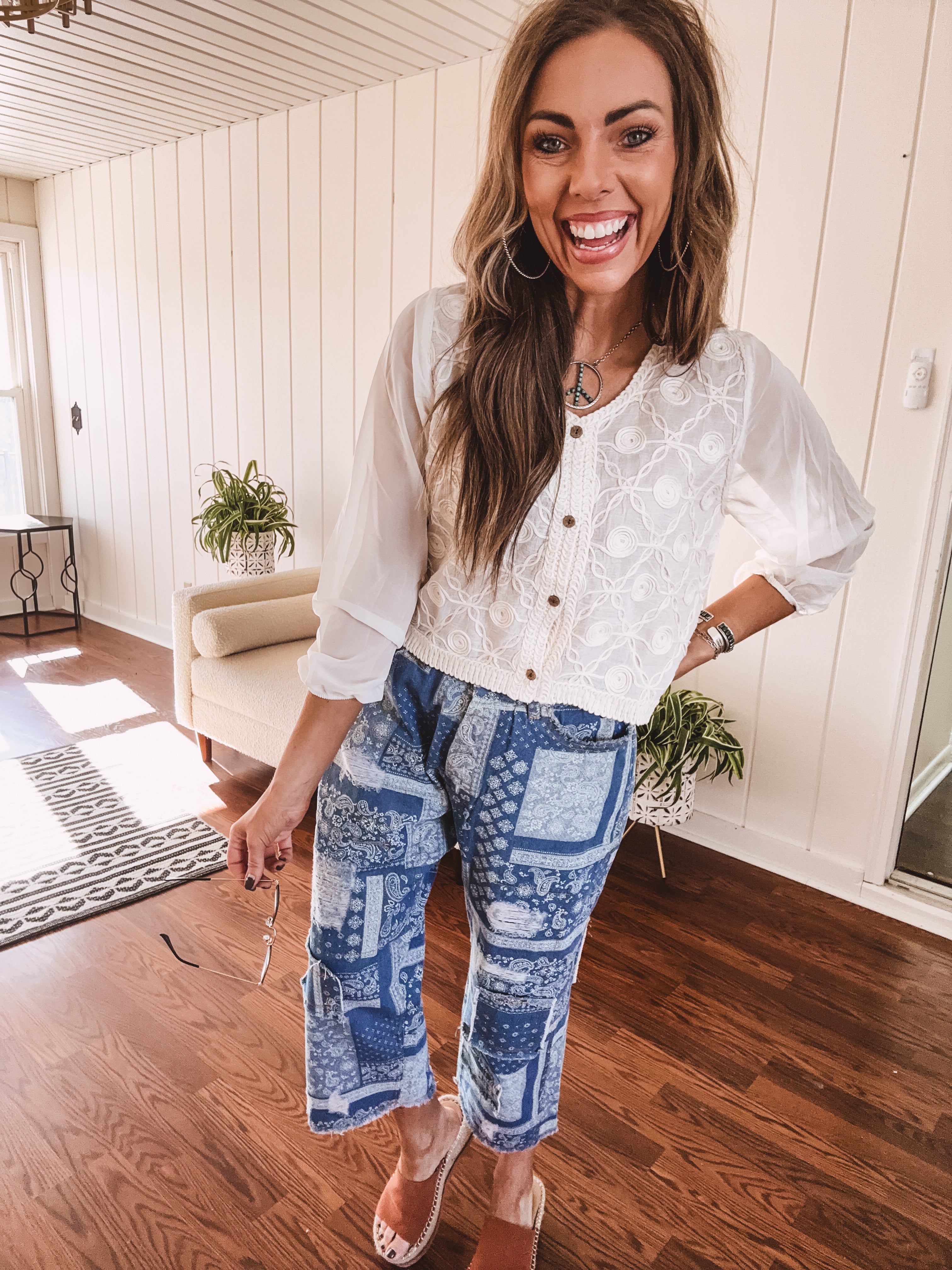 Short sheer beige button down long sleeved top with whimsical embroidery throughout and elastic cuffs.