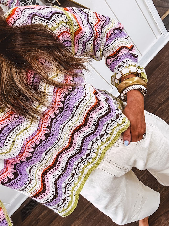 Lightweight cropped crochet long sleeved round neck pullover in pink, white, sage, orange and purple wave design.