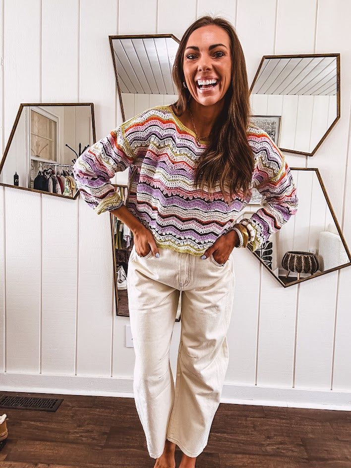 Lightweight cropped crochet long sleeved round neck pullover in pink, white, sage, orange and purple wave design.
