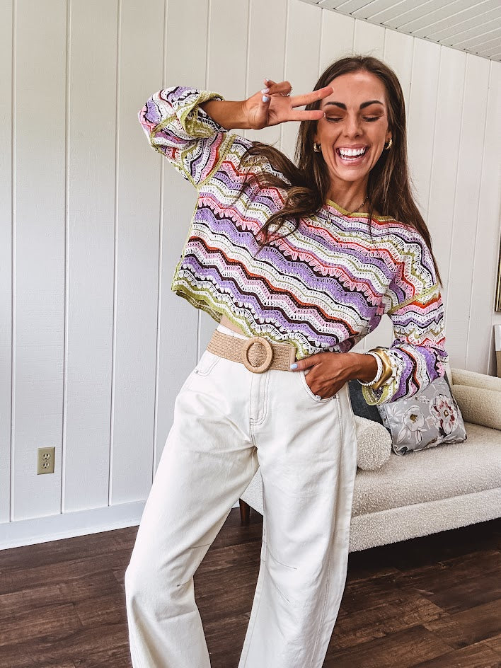 Lightweight cropped crochet long sleeved round neck pullover in pink, white, sage, orange and purple wave design.