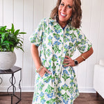 Cream shirt dress with blue and green floral print throughout, contrasting blue trim at the covered placket and hem, cuffed sleeves, mini length, fully lined.
