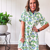 Cream shirt dress with blue and green floral print throughout, contrasting blue trim at the covered placket and hem, cuffed sleeves, mini length, fully lined.