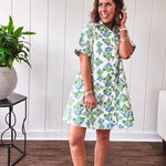 Cream shirt dress with blue and green floral print throughout, contrasting blue trim at the covered placket and hem, cuffed sleeves, mini length, fully lined.