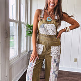 Light olive green washed cotton overalls with pastel floral patchwork throughout including on the adjustable traps with metal clasps and zippered sides.